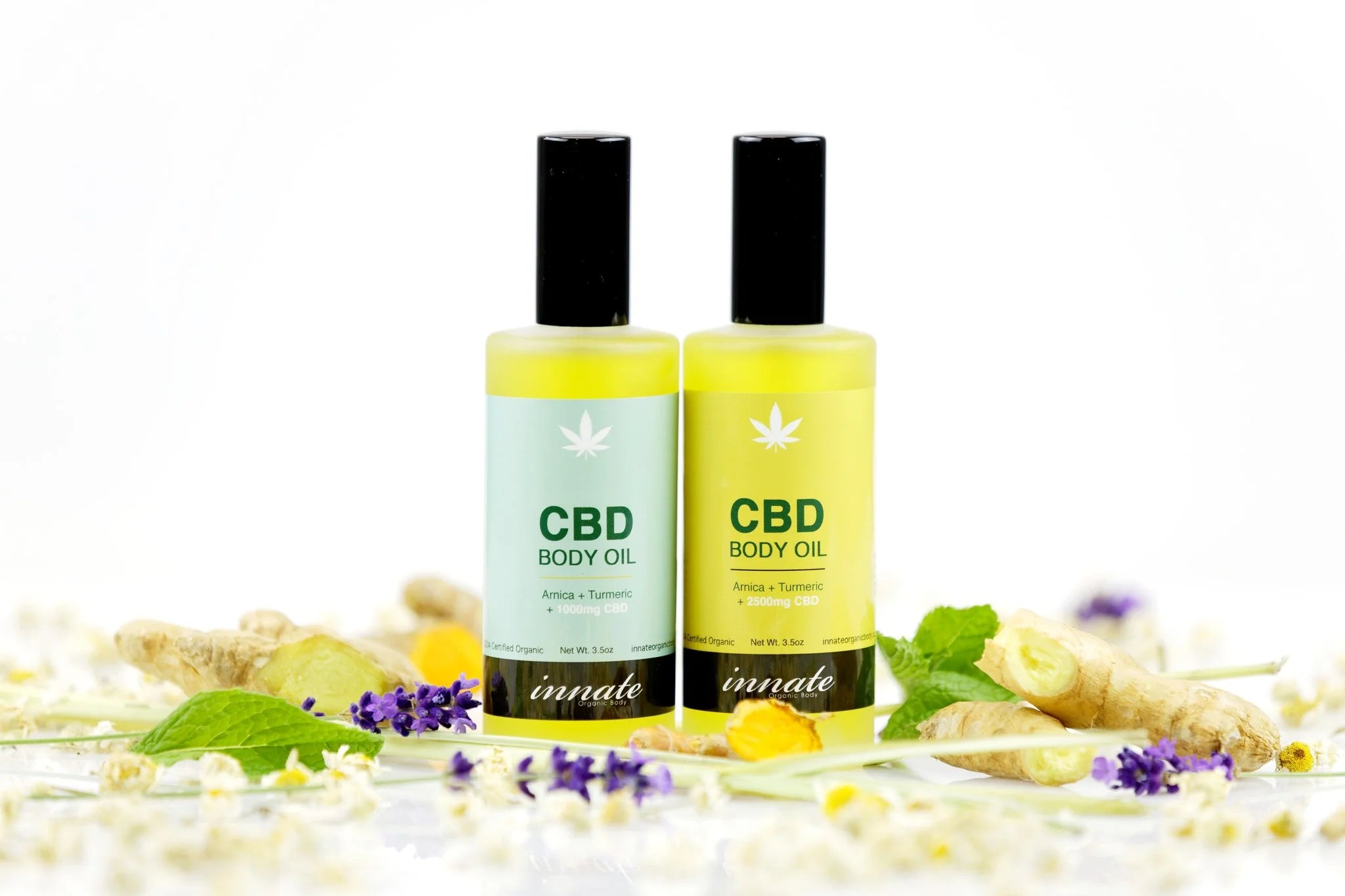 Two bottles of CBD body oil with a natural background